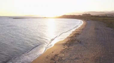 Gün batımında plajda köpekli kız. Havadan görünüm. Almerimar, Almeria, Ispanya