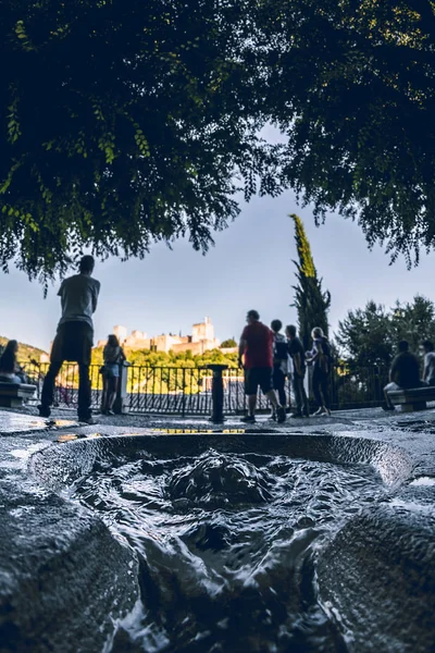 Carvajales viewpoint. Unrecognizable people walking and looking at the Alhambra Palace. Selective focus