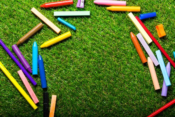 Top view of chalks on green plastic grass. Copy space — Stock Photo, Image