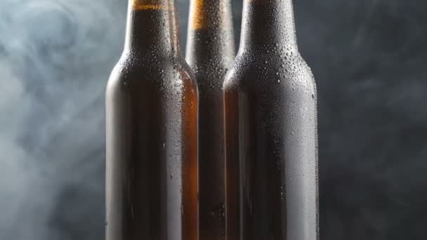 Tres Botellas Cerveza Muy Frías Girando Sobre Fondo Negro — Vídeos de Stock