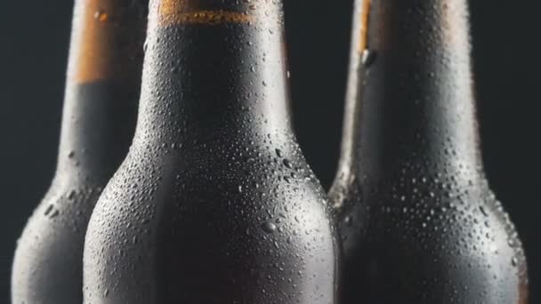 Drie Zeer Koude Bierflesjes Draaiend Zwarte Achtergrond Close — Stockvideo