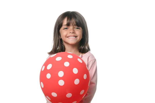 Μελαχρινή κοριτσάκι χαμογελά στην κάμερα με ένα μπαλόνι σε λευκό φόντο — Φωτογραφία Αρχείου