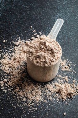 Koyu arka planda üst görünüm peynir altı suyu protein kepçe, kopya alanı