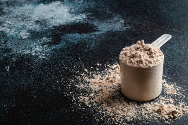 Koyu arka planda üst görünüm peynir altı suyu protein kepçe, kopya alanı