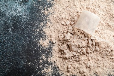 Koyu arka planda üst görünüm peynir altı suyu protein kepçe, kopya alanı