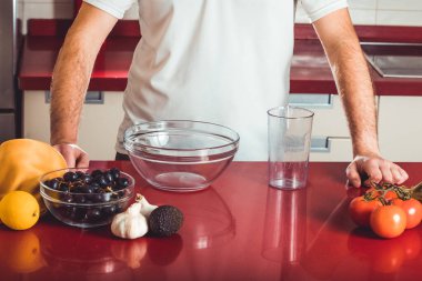 Genç adam yemek yapmak için gerekli malzemeleri hazırladı.