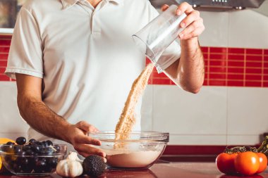 Genç adam yemek yapmak için gerekli malzemeleri hazırladı.