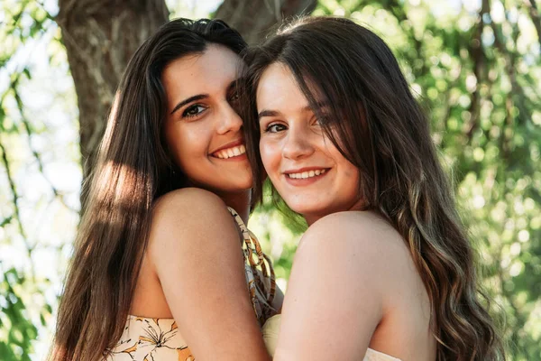 Deux jeunes femmes amies dans la forêt avec des arbres en arrière-plan — Photo
