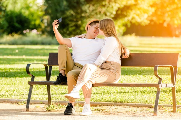 Młoda para robi sobie selfie komórką w parku. Latynoska i kaukaska — Zdjęcie stockowe