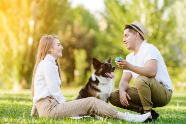 Köpeğiyle parkta eğlenen sevimli bir çift.