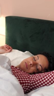 Genç bir kadın uykusundan yavaşça kalkıyor, rahat bir yatak odasında uyanıyor ve uyanıyor, sabah ışığı içinden süzülüyor, beyaz çarşaf ve yastıkların arasına rahatça yerleşiyor. Dikey görüntüler