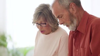 Birlikte belge okumaya odaklanan yaşlı bir çift, belki talimatlar veya önemli bilgiler