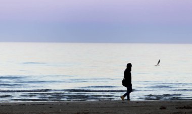 gün batımında denizde duran adamın silueti