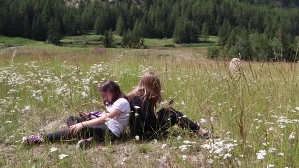 Duas Meninas Assistindo Telefones Sentados Grama Nas Montanhas — Vídeo de Stock