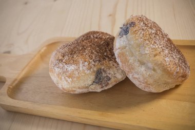 Ahşap masa üzerinde krem dosyalama ile iştah açıcı çörek