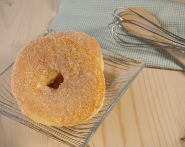 ahşap arka plan üzerinde tepesinde şeker ile ev yapımı sırlı donut
