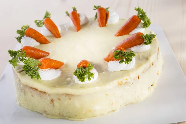 carrot cake decorated with miniature carrots on white tray