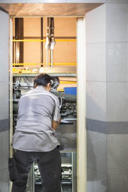 asansör kaldırma şekilde spanners ile asansör ayarlama iş yerinde elektrikçi geri görünümü