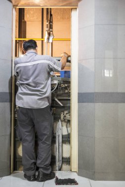 asansör kaldırma şekilde spanners ile asansör ayarlama iş yerinde elektrikçi geri görünümü