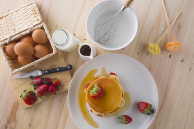 Çilek, muz ve beyaz tabakta bal ile iştah açıcı krep