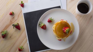 Çilek, muz ve beyaz tabakta bal ile iştah açıcı krep