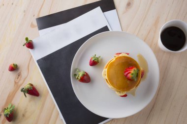 Çilek, muz ve beyaz tabakta bal ile iştah açıcı krep