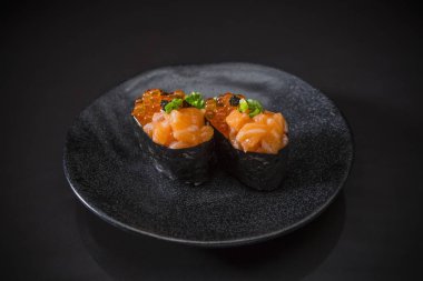 Ikura somon Nigiri, somon Somon yumurta ile tepesinde suşi somon ikura nigiri hizmet seramik tabak, Japon yemekleri stil, siyah arka plan, seçici odak üzerinde geleneksel Japon gıda