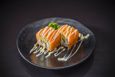 Seramik tabak üzerinde geleneksel Japon yemekleri servis mayonez soslu karides yumurta Roll, Japon yemekleri stil, Sushi Menüsü, pirinç rulo suşi rulo siyah arka plan üzerine, seçici odak