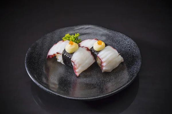 たこにぎり 寿司たこたこ寿司 寿司にぎり 黒の背景 選択と集中にタコ 日本語メニューの日本食スタイル セラミック皿で伝統的な日本料理を提供しています — ストック写真