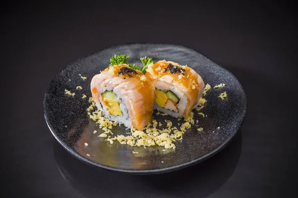 Salmon Sushi-Roll with  sauce and Tempura, Japanese food on ceramic dish, Japanese food style, Sushi Menu, salmon sushi roll on black background, selective focus
