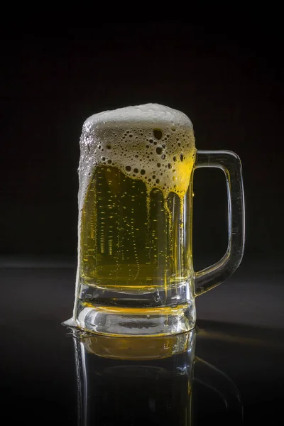 Pint glass with beer on black background, Glass of cold light beer with foam