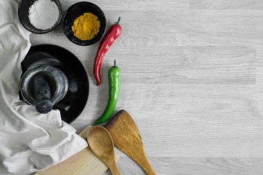 Çatal bıçak takımı baharat, chilies ve harç ile ahşap masa arka plan ayarla. Mutfak gereçleri.