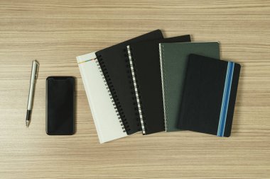 Ahşap arka plan smartphone ile ilgili kitaplar ve kalem ahşap arka plan üzerinde dağınık yığını.
