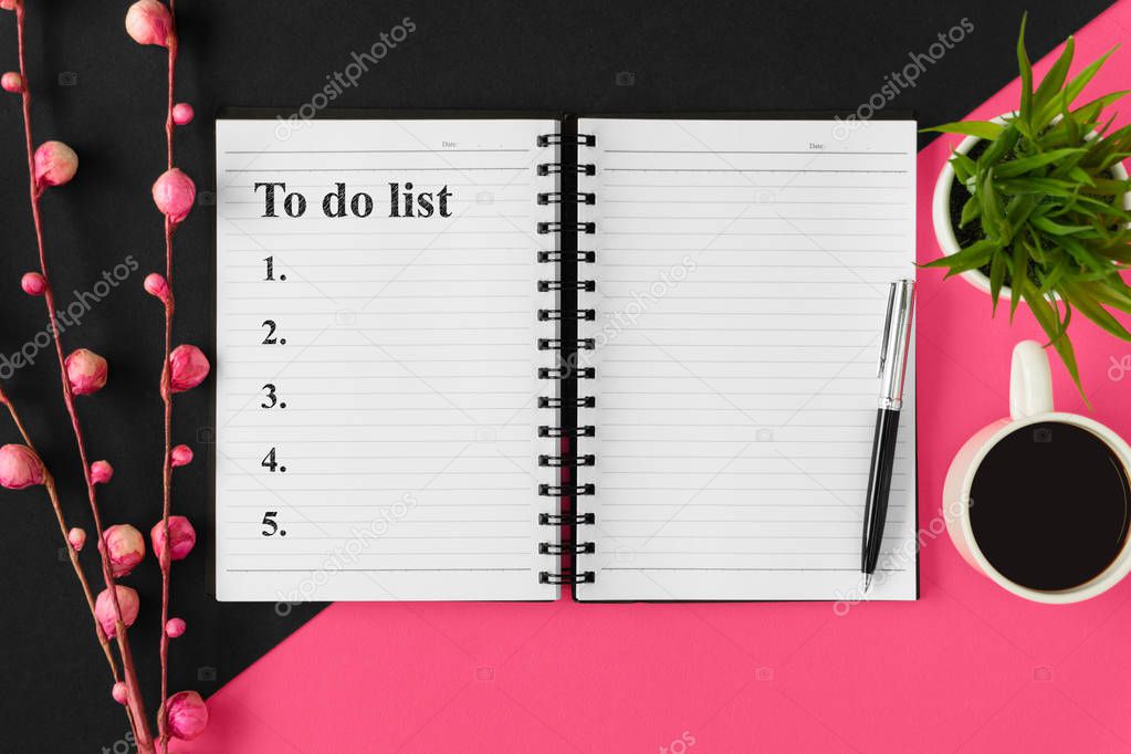 To do list. Notebook and coffee on pink and black background.