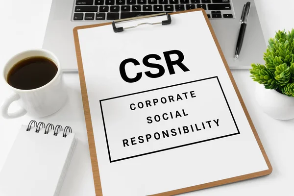 CSR Corporate Social Responsibility on white paper placed on top of laptop computer.