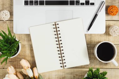 Defter üstünde tepe-in laptop ile ahşap arka plan üzerinde kahve. Rustik nostalji düz yatıyordu.