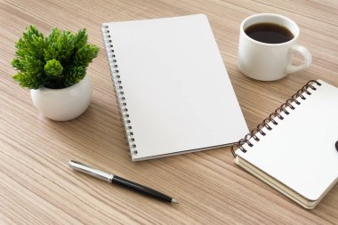 Defter ile kahve fincanı ve ahşap masa üzerinde Saksı bitki. Metin kopya alanı.
