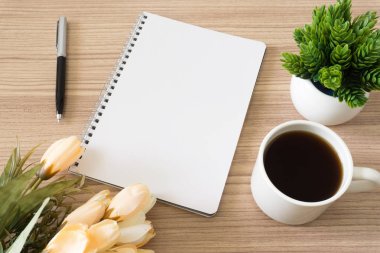 Defter ile kahve fincanı, Saksı bitki ve çiçek ahşap masa üzerinde. Metin kopya alanı.