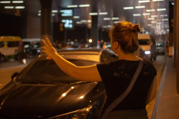 Taksi için arayan kadın.