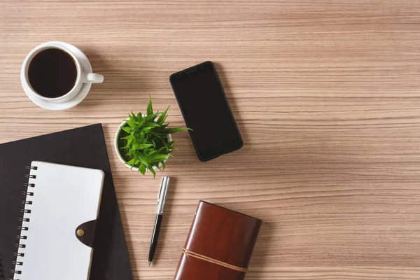 Notepad, kopi dan ponsel dengan latar belakang kayu. Home busine — Stok Foto