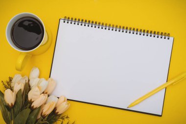 Sarı Arka Plan Üzerinde Çiçek li Not Defteri ve Kahve Fincanı