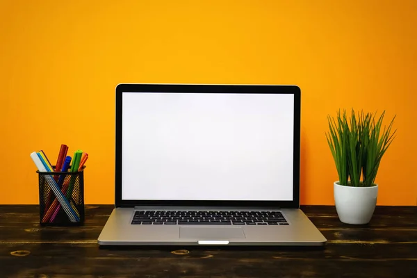 Laptop dengan Layar Putih Kosong pada Kayu Rustik, melawan Latar Belakang Kuning . — Stok Foto