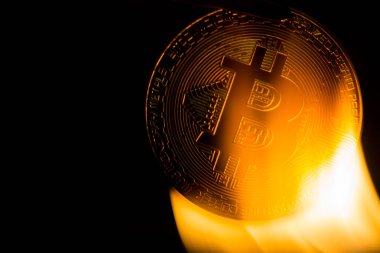 Koyu arka plan üzerinde yanan bitcoin