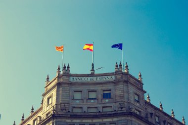 Barcelona, İspanya - 27 Nisan 2018: Bank İspanya bina Plaza Catalunya Barcelona merkezi bayraklı.