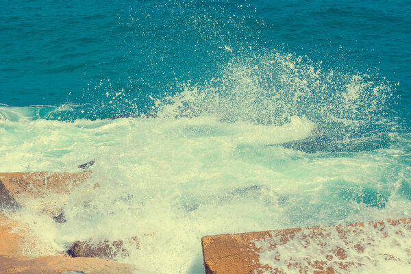 Waves break on a breakwater on the beach near the pier in Barcelona in Spain