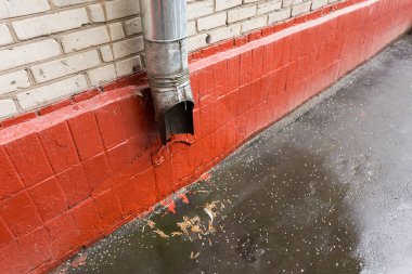 Demir galvaniz pis su borusu bir evin duvarında