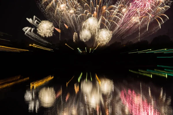 Beautiful fireworks with reflection in the pond with zoom effect
