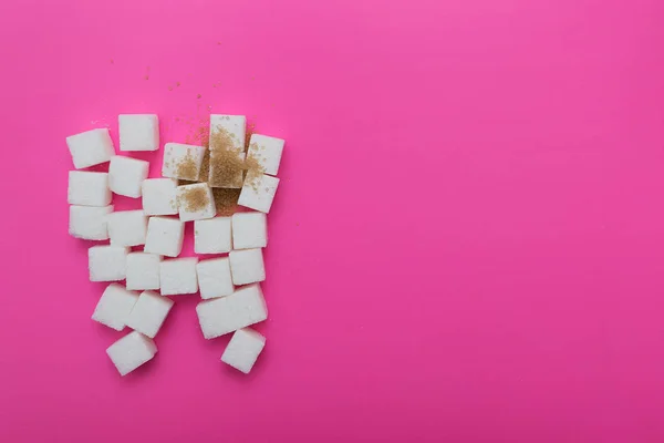 the sugar cubes on the pink background, the theme of the cavities from the sweet