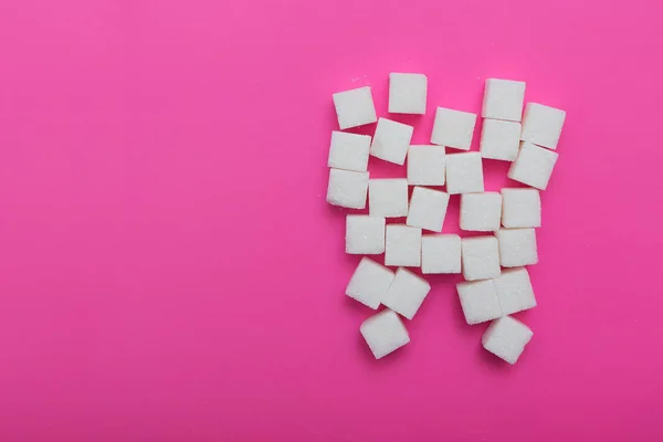 the sugar cubes on the pink background, the theme of the cavities from the sweet