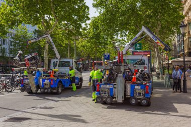 Barcelona, İspanya - 27 Nisan 2018: Çekme hizmeti yasadışı park edilmiş motorlu bisikletler ve motosikletler santral Barselona, sokak Passeig de Gracia Batllo bina yakınındaki kaldırır